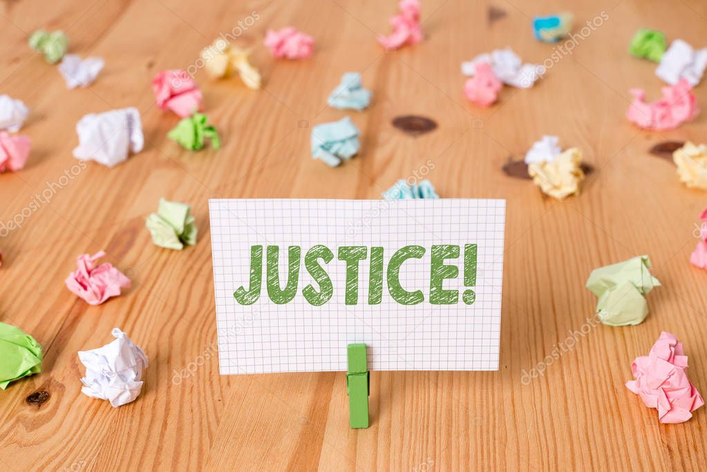 Conceptual hand writing showing Justice. Business photo showcasing impartial adjustment of conflicting claims or assignments Colored crumpled papers wooden floor background clothespin.