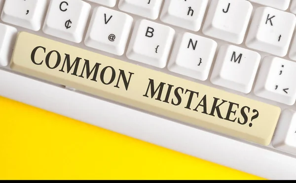 Handwriting text writing Common Mistakes question. Concept meaning repeat act or judgement misguided or wrong White pc keyboard with empty note paper above white background key copy space.