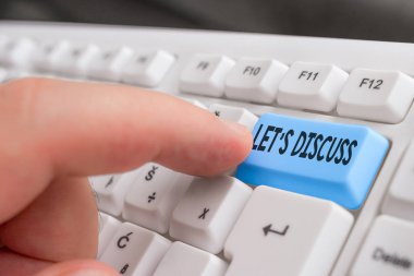 Let S Discuss'ı gösteren not yazma. Beyaz bilgisayar klavyesini beyaz arka planın üzerinde not kağıdıyla gösteren veya gösteren bir şey hakkında konuşmak isteyen birinden soran iş fotoğrafı.