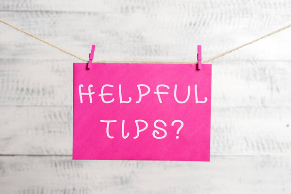 Word writing text Helpful Tips Question. Business concept for secret information or advice given to be helpful knowledge Clothesline clothespin rectangle shaped paper reminder white wood desk.