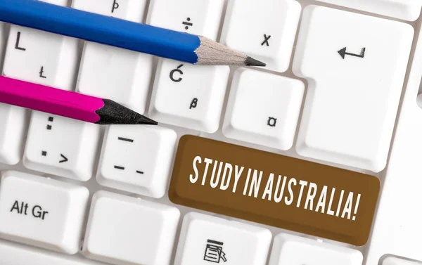Conceptual hand writing showing Study In Australia. Business photo text going into foreign country order complete your studies White pc keyboard with note paper above the white background. — Stock Photo, Image