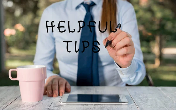 Writing note showing Helpful Tips. Business photo showcasing advices given to be helpful knowledge in life Female business person sitting by table and holding mobile phone. — Stock Photo, Image