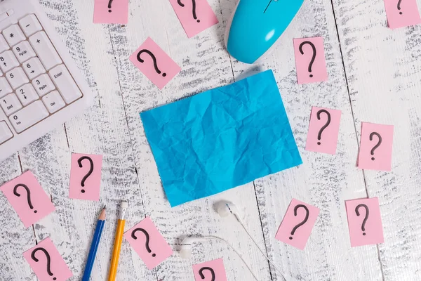 Matériel d'écriture et des trucs informatiques ainsi que du papier griffonné placé sur une toile de fond en bois. Feuille de notes stationnaire près des outils de la machine de traitement de l'information au-dessus de la table blanche . — Photo