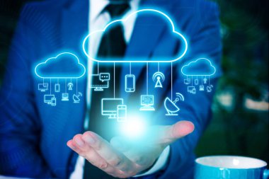 Erkek insan en son gelişmiş cihazları kullanarak sunum yapıyor. Adam, akıllı aletlerin nasıl çalıştığını gösteren resmi bir takım elbise giyiyor. Modern hayatın fotoğrafı..