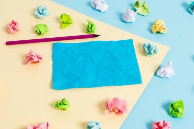 Renkli buruşuk levhalar ve boş dikdörtgen şekilli hatırlatma notu mavi bir arka plan ve sarı kare ortasında yerleştirilir. Ofis malzemeleri, bağlantı elemanı.