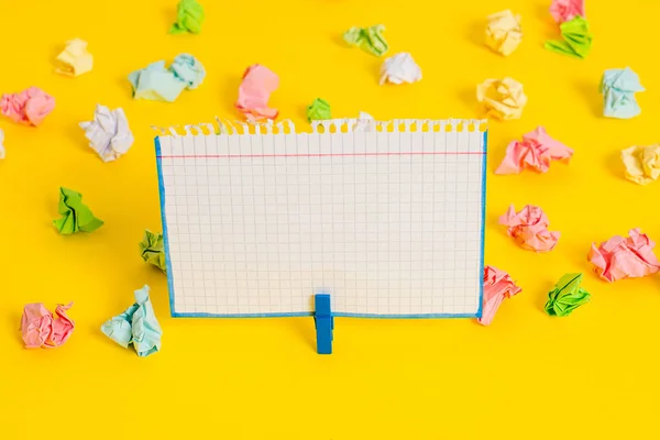 Hojas arrugadas de color colocadas alrededor del rectángulo vacío en forma cuadrada nota recordatorio en el fondo amarillo. Material de oficina, papel en blanco fijado por un cierre. — Foto de Stock