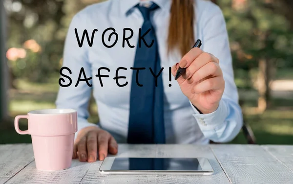 写说明工作安全。商务照片展示确保员工健康的政策和程序 女性商务人士坐在桌旁，手持手机. — 图库照片