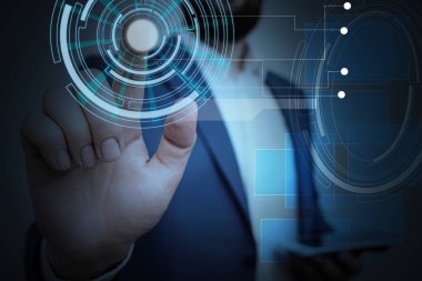 Erkek insan en son gelişmiş cihazları kullanarak sunum yapıyor. Adam, akıllı aletlerin nasıl çalıştığını gösteren resmi bir takım elbise giyiyor. Modern hayatın fotoğrafı..