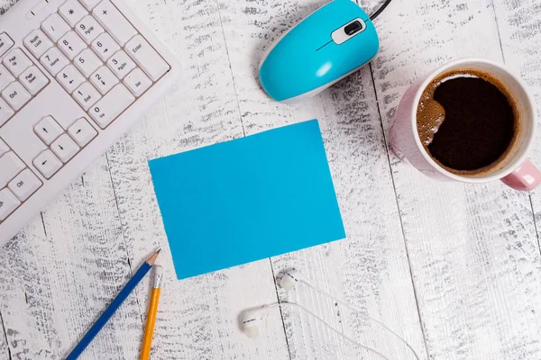 Rectangle carré note de papier vide au-dessus d'un plancher en bois blanc, clavier d'ordinateur et souris. Tasse de café et crayons autour du rappel. Fournitures de bureau, espace vide . — Photo