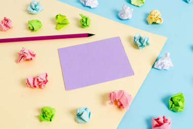 Renkli buruşuk levhalar ve boş dikdörtgen şekilli hatırlatma notu mavi bir arka plan ve sarı kare ortasında yerleştirilir. Ofis malzemeleri, bağlantı elemanı.