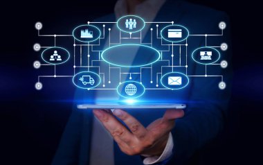 Erkek insan en son gelişmiş cihazları kullanarak sunum yapıyor. Adam, akıllı aletlerin nasıl çalıştığını gösteren resmi bir takım elbise giyiyor. Modern hayatın fotoğrafı..