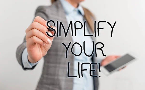 Text sign showing Simplify Your Life. Conceptual photo focused on important and let someone else worry about less ones Business woman pointing in empty space with pen and mobile phone.