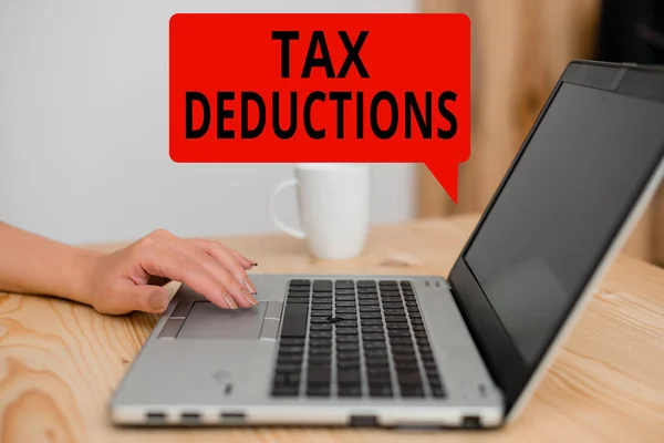 Text sign showing Tax Deductions. Conceptual photo an amount or cost that subtracted from someone s is income woman laptop computer smartphone mug office supplies technological devices. — Stock Photo, Image