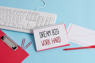Dream Big Work Hard 'ı gösteren bir not yazıyorum. İş fotoğrafı gösterimi Kendine inan ve hayalleri ve hedefleri takip et Kağıt mavisi klavye ofis çalışma defteri çizelgesi notları.