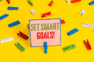 Kelime yazma metni Set Akıllı Hedefler. Fikirlerinizi netleştirmek için liste için iş konsepti odak çabaları zaman akıllıca Renkli clothespin kağıtları boş hatırlatma sarı zemin arka plan ofis kullanın.