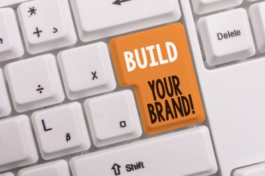 Markanızı Oluştur'u gösteren metin işareti. Kavramsal fotoğraf oluşturur veya beyaz arka plan anahtar kopyalama alanı üzerinde boş not kağıdı ile ürün Beyaz pc klavye müşteri bilgi ve görüşlerini geliştirir.