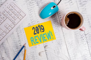 Kavramsal el yazısı 2019 İnceleme gösteren. Geçen yıl olayları ana eylemleri veya iyi hatırlayan İş fotoğraf metin Teknolojik cihazlar renkli hatırlatma kağıt ofis malzemeleri gösterir.