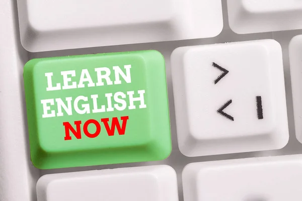 Texto para escribir palabras Aprende inglés ahora. Concepto de negocio para obtener o adquirir conocimientos y habilidades del idioma inglés Teclado blanco para PC con papel de nota vacío sobre el espacio de copia de la tecla de fondo blanco . —  Fotos de Stock