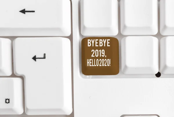 Pisanie notatki pokazano Bye bye 2019 Hello 2020. Business Photo showobudowy pożegnanie z ubiegłego roku i powitanie kolejny dobry jeden biały klawiatura PC z papieru notatki powyżej białego tła. — Zdjęcie stockowe