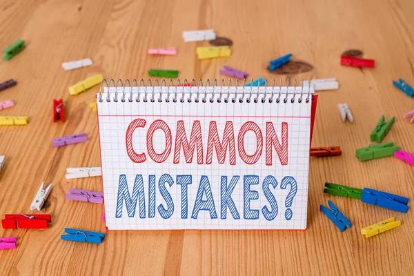 Handwriting text writing Common Mistakes Question. Concept meaning repeat act or judgement misguided making something wrong Colored clothespin papers empty reminder wooden floor background office. — Stock Photo, Image