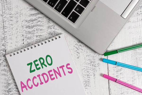 Word writing text Zero Accidents. Business concept for important strategy for preventing workplace accidents Top trendy metallic laptop blank spiral notepad pens lying wooden table.
