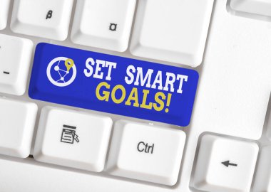 Set Smart Goals'ı gösteren kavramsal el yazısı. Fikirlerinizi netleştirmek için iş fotoğraf vitrin listesi odak çabaları beyaz arka plan üzerinde not kağıdı ile akıllıca beyaz pc klavye kullanın.