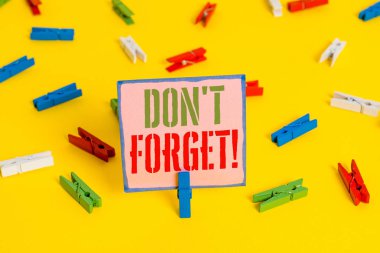 Kelime yazma metni Don T Forget. Önemli gerçeği veya detay Hakkında birisi hatırlatmak için kullanılan iş konsepti Renkli clothespin kağıtları boş hatırlatma sarı zemin arka plan ofis.