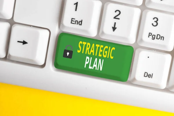 Text sign showing Strategic Plan. Conceptual photo a systematic process of envisioning a desired future White pc keyboard with empty note paper above white background key copy space.