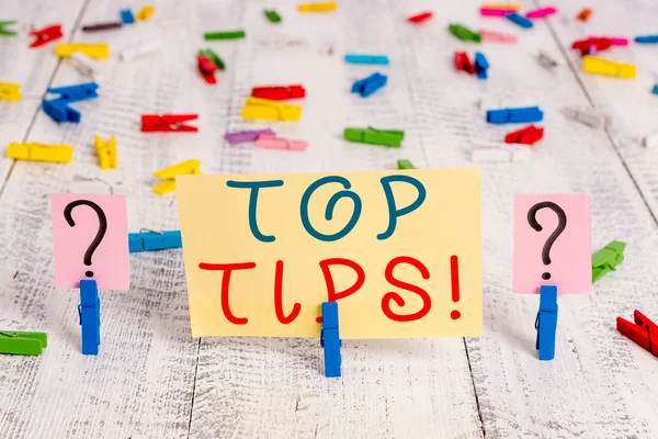 Writing note showing Top Tips. Business photo showcasing small but particularly useful piece of practical advice Crumbling sheet with paper clips placed on the wooden table.