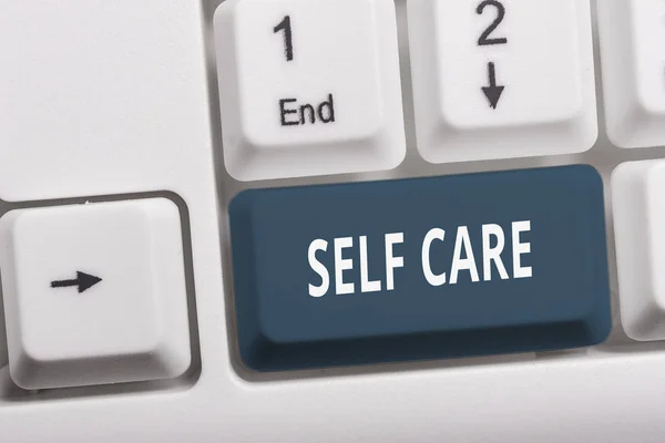 Writing note showing Self Care. Business photo showcasing the practice of taking action to improve one s is own health White pc keyboard with note paper above the white background. — Stock Photo, Image