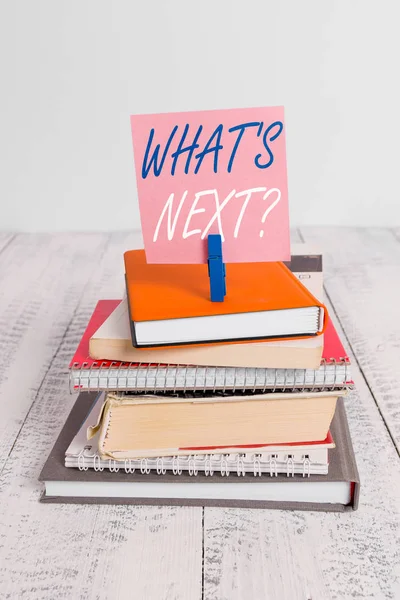 Handwriting text What S Next Question. Concept meaning asking demonstrating about his coming actions or behaviors pile stacked books notebook pin clothespin colored reminder white wooden. — Stock Photo, Image