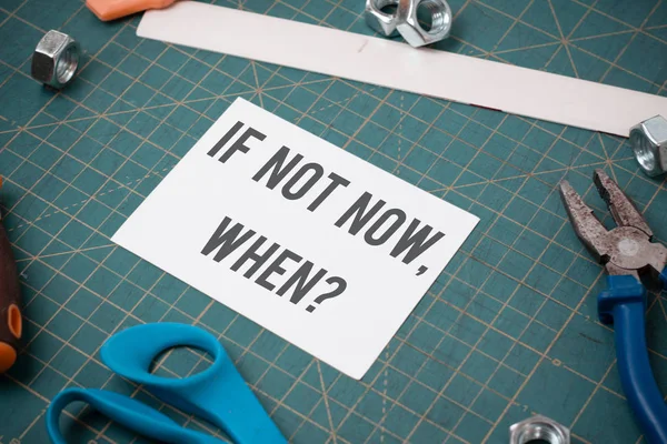 Writing note showing If Not Now When Question. Business photo showcasing start acting from this moment do not hesitate Stationary and carpentry tools with paper above a textured backdrop.