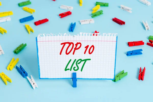 トップ10リストを示すテキスト記号。概念写真特定のリストで最も重要なまたは成功した10のアイテム着色された服のピンペーパー空のリマインダーブルーフロアの背景オフィスピン. — ストック写真