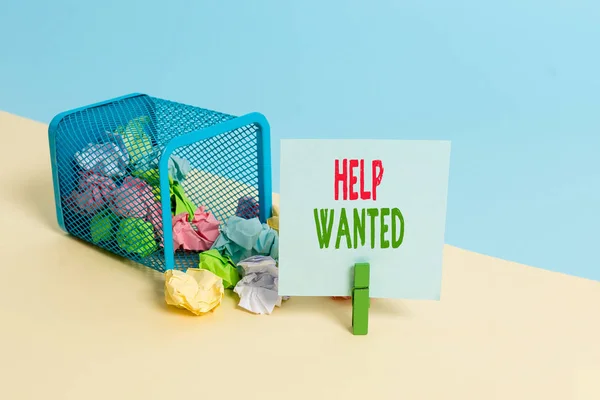 Text sign showing Help Wanted. Conceptual photo An ad in the paper an employer places to find a new employee Trash bin crumpled paper clothespin empty reminder office supplies tipped.