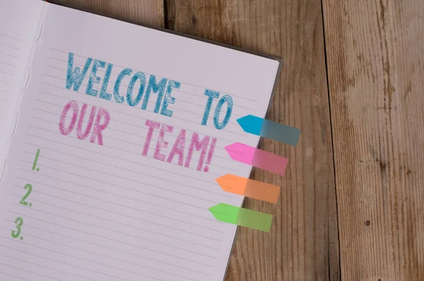 Text sign showing Welcome To Our Team. Conceptual photo introducing another demonstrating to your team mates Striped note book four colored arrow banners reminder wooden background.