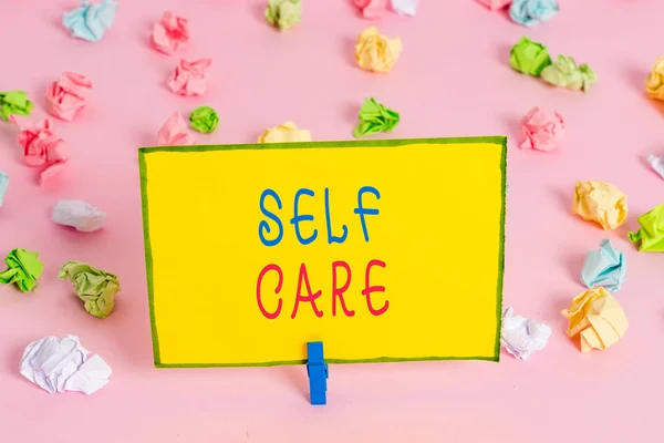 Написание текста Self Care. Business concept for the practice of taking action to improve one 's is own health Colored crumpled papers empty reminder pink floor background clothespin . — стоковое фото