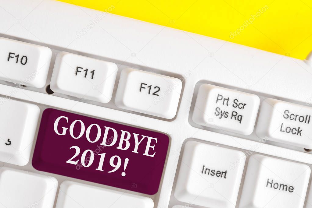 Handwriting text writing Goodbye 2019. Concept meaning express good wishes when parting or at the end of last year White pc keyboard with empty note paper above white background key copy space.