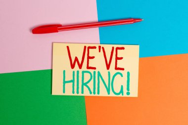 İşe Aldığımızı gösteren kavramsal el yazısı. İş fotoğraf metin son zamanlarda birini istihdam veya belirli bir iş Office cihaz kare masa çalışması malzemeleri kağıt etiket yapmak için birisi ödeme.