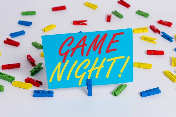 Text sign showing Game Night. Conceptual photo usually its called on adult play dates like poker with friends Colored clothespin papers empty reminder white floor background office.