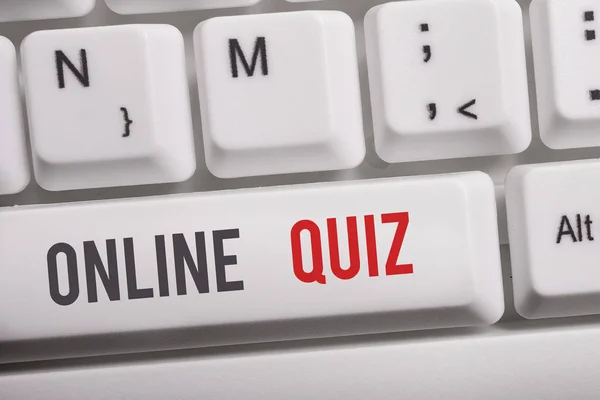 Text sign showing Online Quiz. Conceptual photo game or a mind sport that are published on the Internet White pc keyboard with empty note paper above white background key copy space.