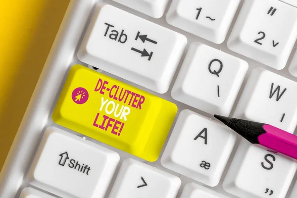 Text sign showing De Clutter Your Life. Conceptual photo remove unnecessary items from untidy or overcrowded places White pc keyboard with empty note paper above white background key copy space. — Stock Photo, Image