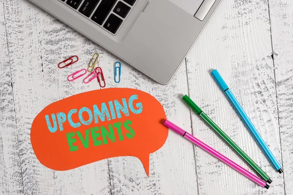 Handwriting text Upcoming Events. Concept meaning the approaching planned public or social occasions Trendy metallic laptop speech bubble colored clips pens lying vintage table.