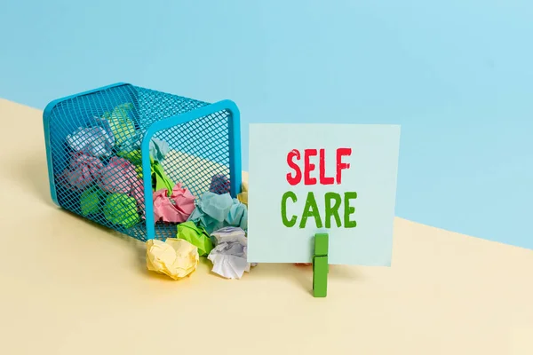 Sinal de texto mostrando Self Care. Foto conceitual a prática de tomar medidas para melhorar um s é a própria saúde Lixo bin enrugado papel clothespin vazio lembrete material de escritório derrubado . — Fotografia de Stock