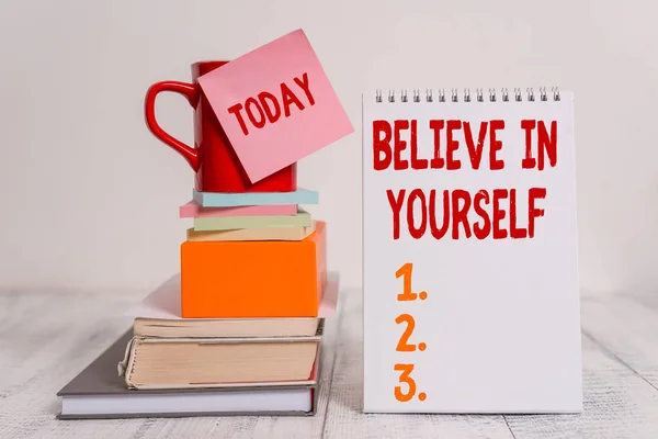 Word writing text Believe In Yourself. Business concept for common piece of advice that you can do everything Cup sticky note stacked note pads books square box spiral wooden table. — Stock Photo, Image