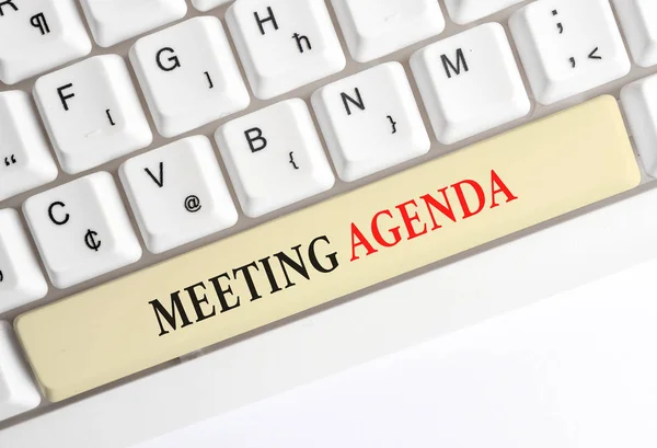 Writing note showing Meeting Agenda. Business photo showcasing items that participants hope to accomplish at a meeting White pc keyboard with note paper above the white background.