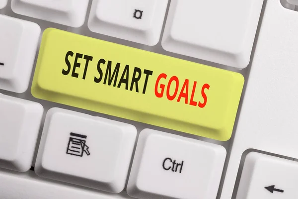 Text sign showing Set Smart Goals. Conceptual photo giving criteria to guide in the setting of objectives White pc keyboard with empty note paper above white background key copy space. — Stock Photo, Image