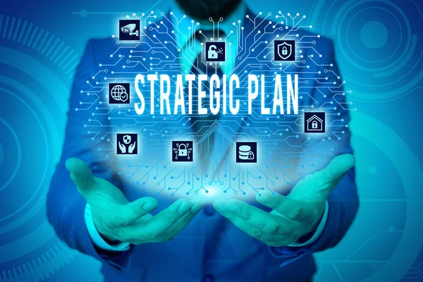 Writing note showing Strategic Plan. Business photo showcasing a systematic process of envisioning a desired future Male wear formal work suit presenting presentation smart device. — Stock Photo, Image
