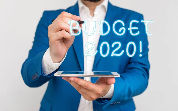 Kézírási szöveg írása költségvetés 2020. Koncepció jelentés becsült bevételek és kiadások a következő vagy folyó évben üzletember ujjal mutatva előtte. — Stock Fotó