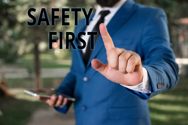 Texte textuel Sécurité d'abord. Concept d'affaires pour l'habitude de dire que la chose la plus importante est d'être en sécurité Homme d'affaires avec le doigt pointant devant lui . — Photo