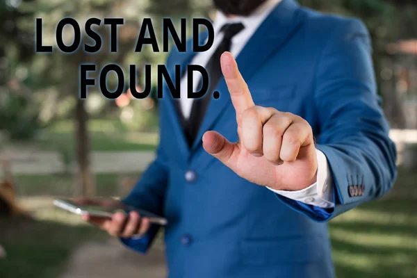 Parola che scrive "Lost And Found". Business concept per un luogo dove gli oggetti smarriti vengono conservati fino a quando non hanno recuperato Businessman con il dito puntato di fronte a lui . — Foto Stock